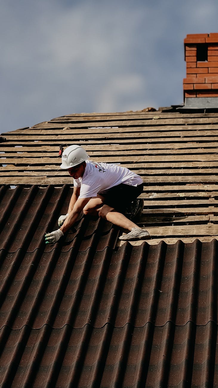 Roofer fastening new tile on a sunlit Arizona home