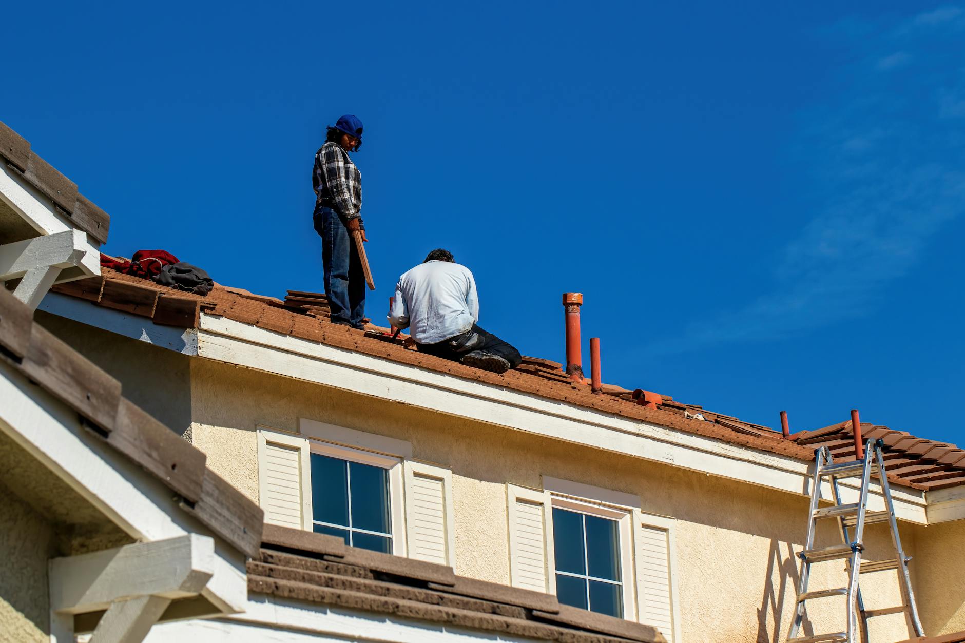 Crew installing underlayment on a roof deck